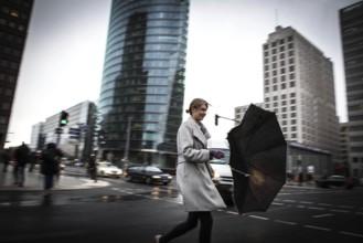 DEU Germany Germany Berlin Woman fighting against the wind at Potsdamer Platz