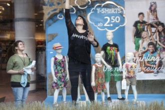 DEU Germany Germany Berlin employees clean a shop window in which the spring collection is on