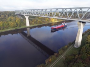 Cargo ship sails under the Grünental High Bridge in autumn through the Kiel Canal, NOK, Kiel Canal,