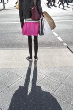 DEU Germany Germany Berlin A woman with shopping bags waits at a pedestrian traffic light on