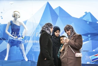 DEU Germany Germany Berlin Women wearing headscarves look at an Apple iPhone. You are standing in