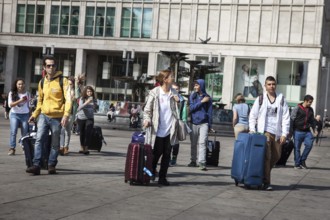 DEU Germany Germany Berlin Tourists pull their trolleys across Alexanderplatz