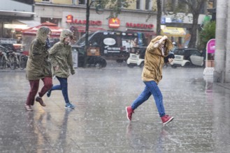 DEU Germany Germany Berlin Young woman running through the rain
