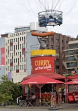 Curry at the Wall snack bar with passengers in the HiFlyer World Balloon, bizarre scene,