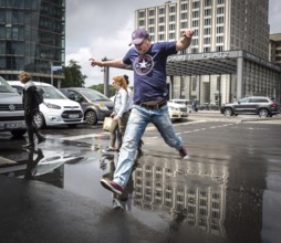 DEU Germany Germany Berlin Pedestrians jump over a cap at Potsdamer Pltz