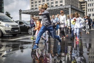DEU Germany Germany Berlin Pedestrians jump over a cap at Potsdamer Pltz