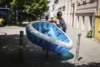DEU Germany Germany Berlin A woman transports a paddling pool on her bicycle in Prenzlauer Berg