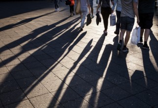 DEU Germany Germany Berlin People with shopping bags cast their shadows on the sidewalk of the cow