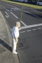 DEU Germany Germany Berlin A man stands with a green pole at a pedestrian traffic light