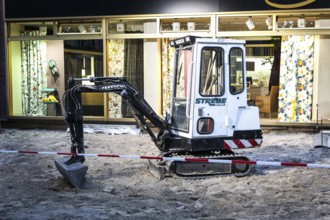 DEU Germany Germany Berlin A small excavator stands in front of an interior decoration shop