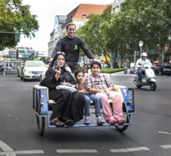 DEU Germany Germany Berlin A woman rides over Tauentzien in a rickshaw with her children