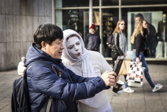 DEU Germany Germany Berlin A tourist takes a selfie with a white-painted woman on the Kudamm. The