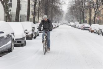 DEU Germany Germany Berlin Cyclists on snow-covered road in Schöneberg