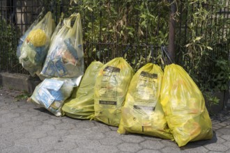 Yellow bags for plastic waste are lying on the side of the road, waste separation, waste disposal,