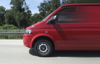Driving scenery including a red minibus on the road