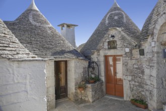 Sunny impression of trulli houses at a town named Alberobello in Apulia, Italy