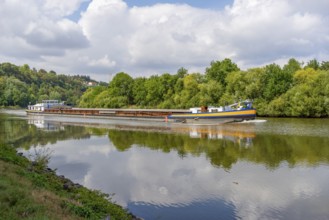 Cargo ship on a river at summer time in sunny ambiance