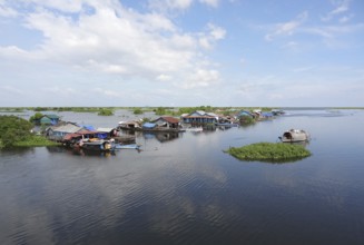Waterside scenery with rural houses and boats at the Tonle Sap, a river in Cambodia
