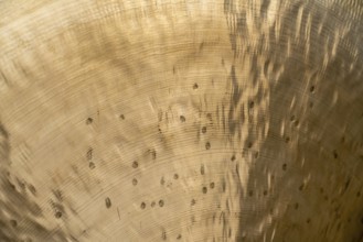 Full frame abstract closeup shot of a metallic asian gong