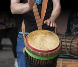 Detail of a djembe drum player in dark back