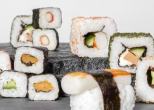 Various sushi dishes on dark grey stone surface