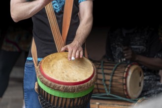 Detail of a djembe drum player in dark back
