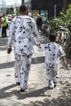 DEU Germany Germany Berlin An African father-and-son team walks along Rudi-Dutschke-Straße wearing
