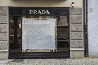 DEU Germany Germany Berlin A shop window of the luxury fashion company Prada is covered with a