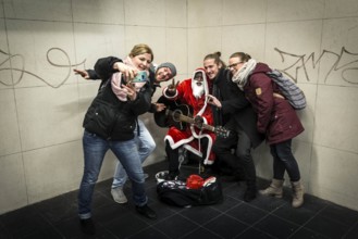 DEU Germany Germany Berlin A dark-skinned singer dressed as Father Christmas plays the guitar in
