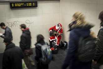 DEU Germany Germany Berlin A dark-skinned singer dressed as Father Christmas plays the guitar in