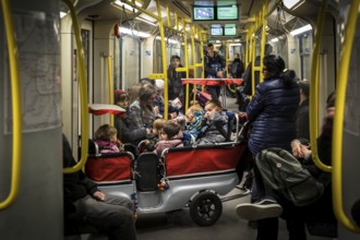 DEU Germany Germany Berlin Carer with pram for several kindergarten children in the underground