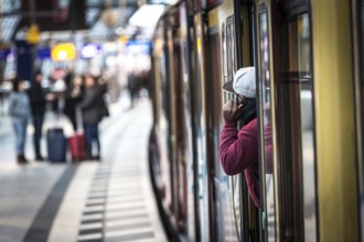 DEU Germany Germany Berlin A traveller makes a phone call from an S-Bahn train at the main station