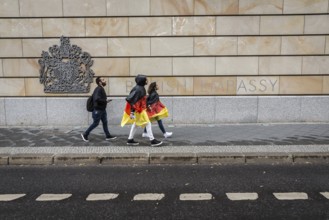 DEU Germany Germany Berlin Two tourists with rain capes in the colours of Germany pass the British