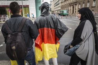 DEU Germany Germany Berlin Two tourists with rain capes in the colours of Germany are accompanied