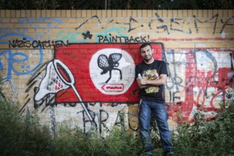Germany Germany DEU Berlin Graffiti artist Ibo Omari in front of one of his works on a playground