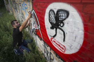 Germany Germany DEU Berlin Graffiti artist Ibo Omari in front of one of his works on a playground