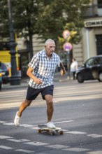 DEU Germany Germany Berlin Elderly man with skateboard in West Berlin corner Kurfürstendamm