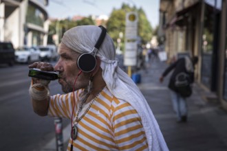 DEU Germany Germany Berlin A homeless man holds his mobile phone and a book in his hand
