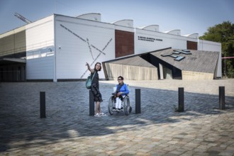 DEU Germany Germany Berlin Disabled tourist in a wheelchair explores Berlin with a city guide.