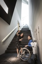 DEU Germany Germany Berlin Disabled tourist in a wheelchair explores Berlin with a city guide.