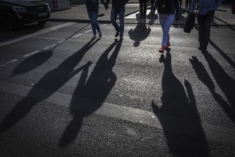 DEU Germany Germany Berlin Pedestrians cast their shadows on the street at Potsdamer Platz