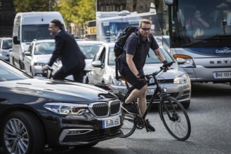DEU Germany Germany Berlin Cyclist between cars in heavy traffic in the city centre
