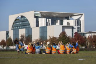 DEU Germany Germany Berlin Kindergarten children raise their hands for a group photo in front of