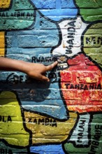 RWA RWANDA Rwanda Gahini A pupil shows Rwanda on a map of Africa painted on the wall