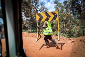 RWA RWANDA Rwanda Rusumo A worker carries a road sign across a construction site