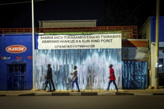 RWA RWANDA Rwanda Kigali people pass closed shops at night
