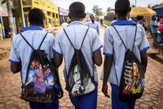 RWA RWANDA Rwanda Kayonza students in uniform carry backpacks with their idols Lionel Messi and Bob
