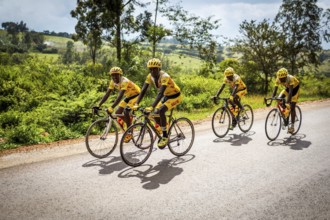 RWA RWANDA Rwanda Gahini cyclists train on a road at Lake Muhazi