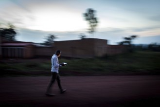 RWA RWANDA Rwanda Rukara A student looks at his smartphone while walking
