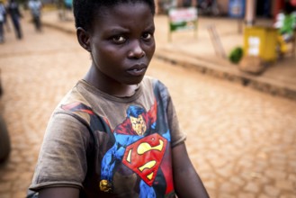 RWA RWANDA Rwanda Kayonza A young woman with a bicycle shows her Superman shirt